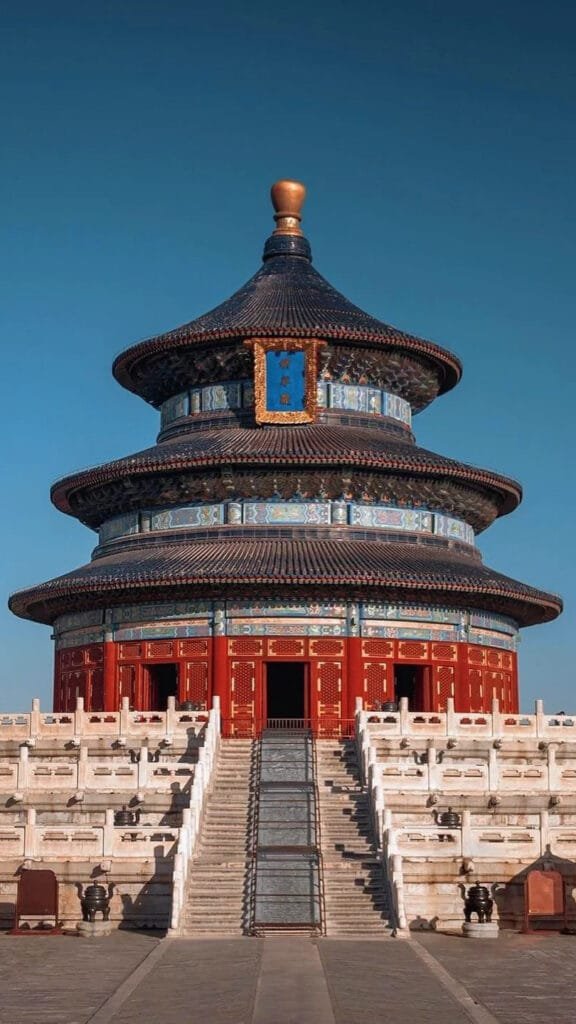 a circular building with a steeple with Temple of Heaven in the background in Beijing